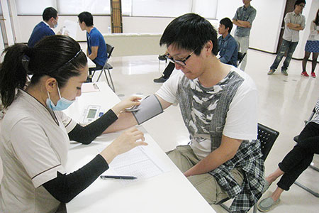 健康の紹介：女性看護師が留学生（男性）を診療している写真